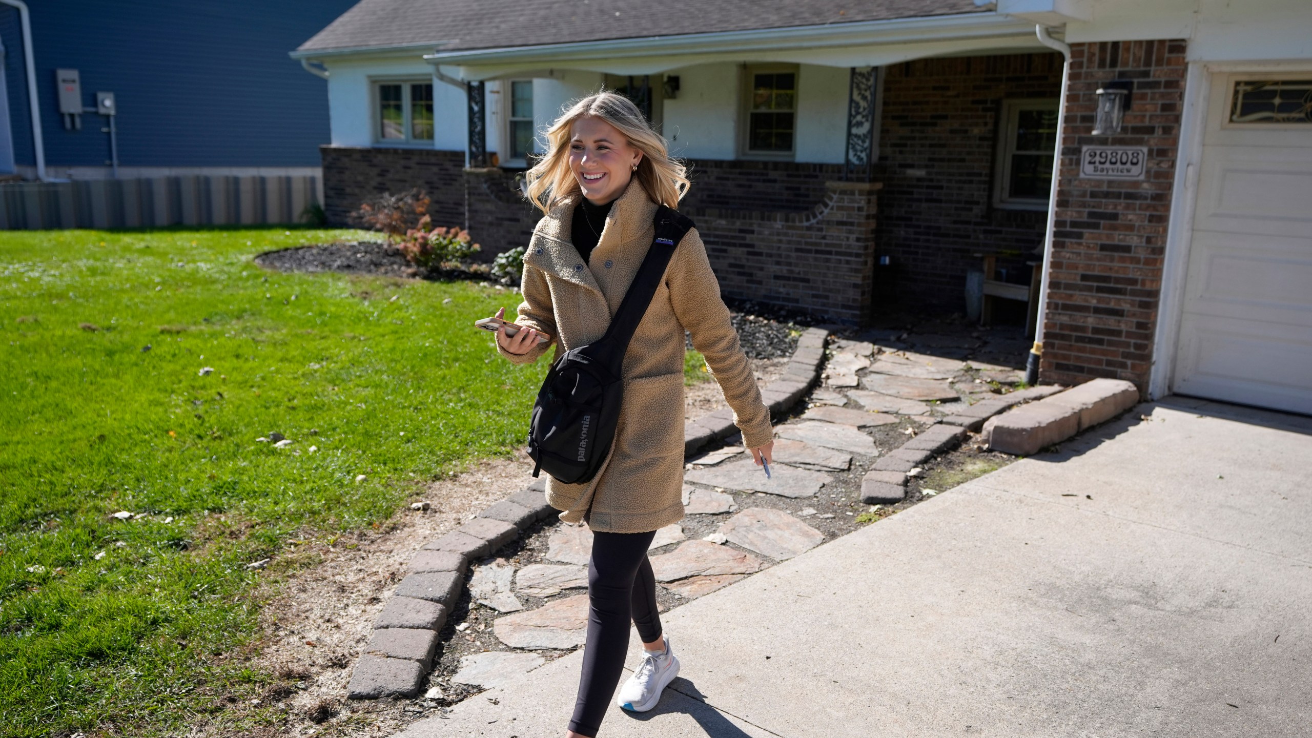 Republican Rylee Linting walks door to door campaigning hoping to unseat Democratic State Rep. Jaime Churches, Wednesday, Oct. 16, 2024, in Gibraltar, Mich. (AP Photo/Carlos Osorio)