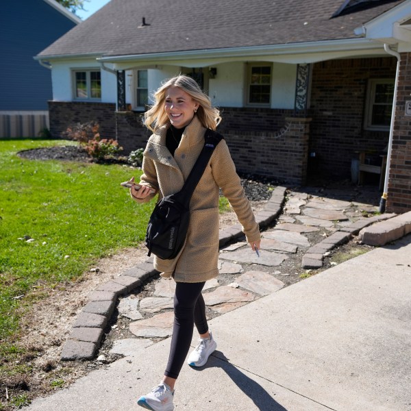 Republican Rylee Linting walks door to door campaigning hoping to unseat Democratic State Rep. Jaime Churches, Wednesday, Oct. 16, 2024, in Gibraltar, Mich. (AP Photo/Carlos Osorio)