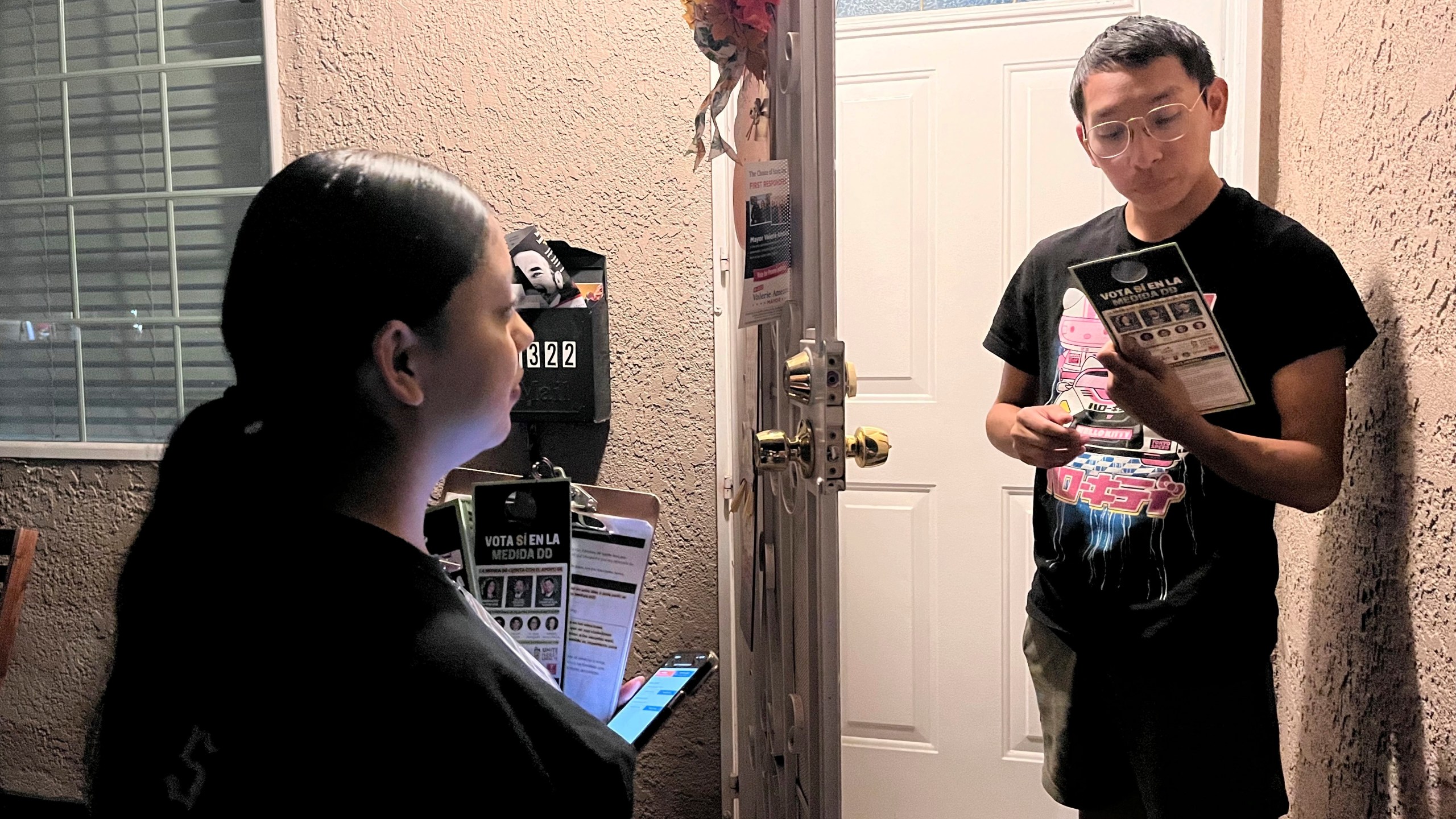 Genesis Lopez, 21, speaks with Santa Ana, Calif. resident Eduardo Entimio, 23, on Wednesday, Oct. 23, 2024, about Measure DD, which would allow noncitizens to vote in local elections. (AP Photo/Jaimie Ding)