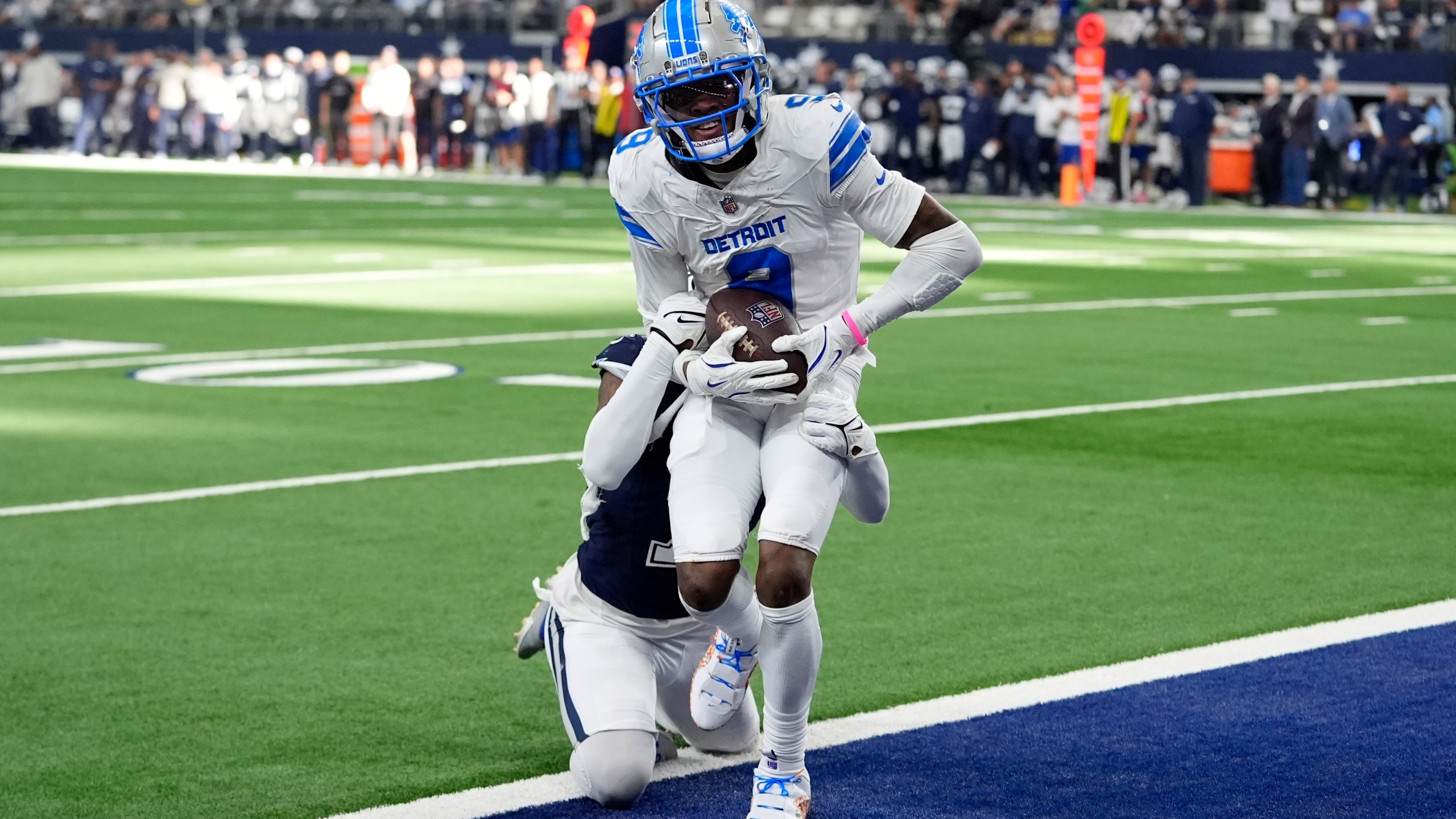 Detroit Lions wide receiver Jameson Williams (9) catches a touchdown pass as Dallas Cowboys cornerback Trevon Diggs, rear, defends in the second half of an NFL football game in Arlington, Texas, Sunday, Oct. 13, 2024. (AP Photo/LM Otero)