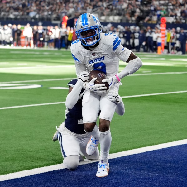 Detroit Lions wide receiver Jameson Williams (9) catches a touchdown pass as Dallas Cowboys cornerback Trevon Diggs, rear, defends in the second half of an NFL football game in Arlington, Texas, Sunday, Oct. 13, 2024. (AP Photo/LM Otero)