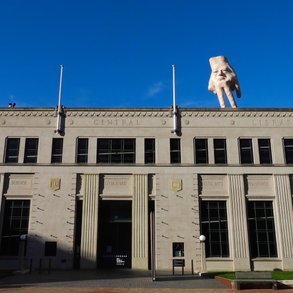 A 16-foot- ( almost 5 meters ) tall hand sculpture named Quasi stands perched on its fingertips atop the roof of an art gallery in Wellington, New Zealand, Wednesday, Oct. 30, 2024. (AP photo/Charlotte Graham-McLay)