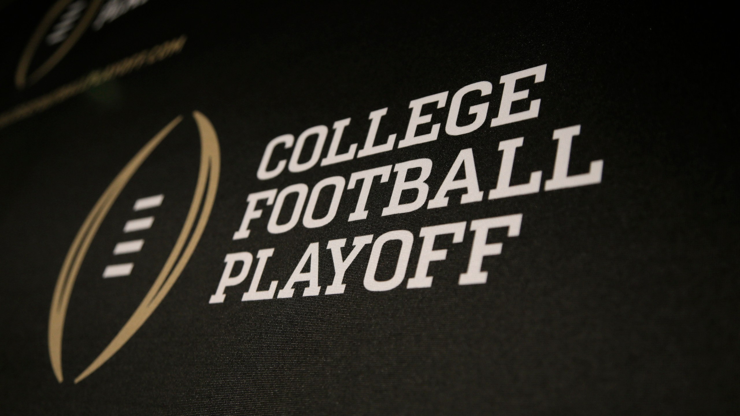 FILE - The College Football Playoff logo is printed across a backdrop during a news conference where the 13 members of the committee were announced, Oct. 16, 2013, in Irving, Texas. (AP Photo/Tony Gutierrez, File)