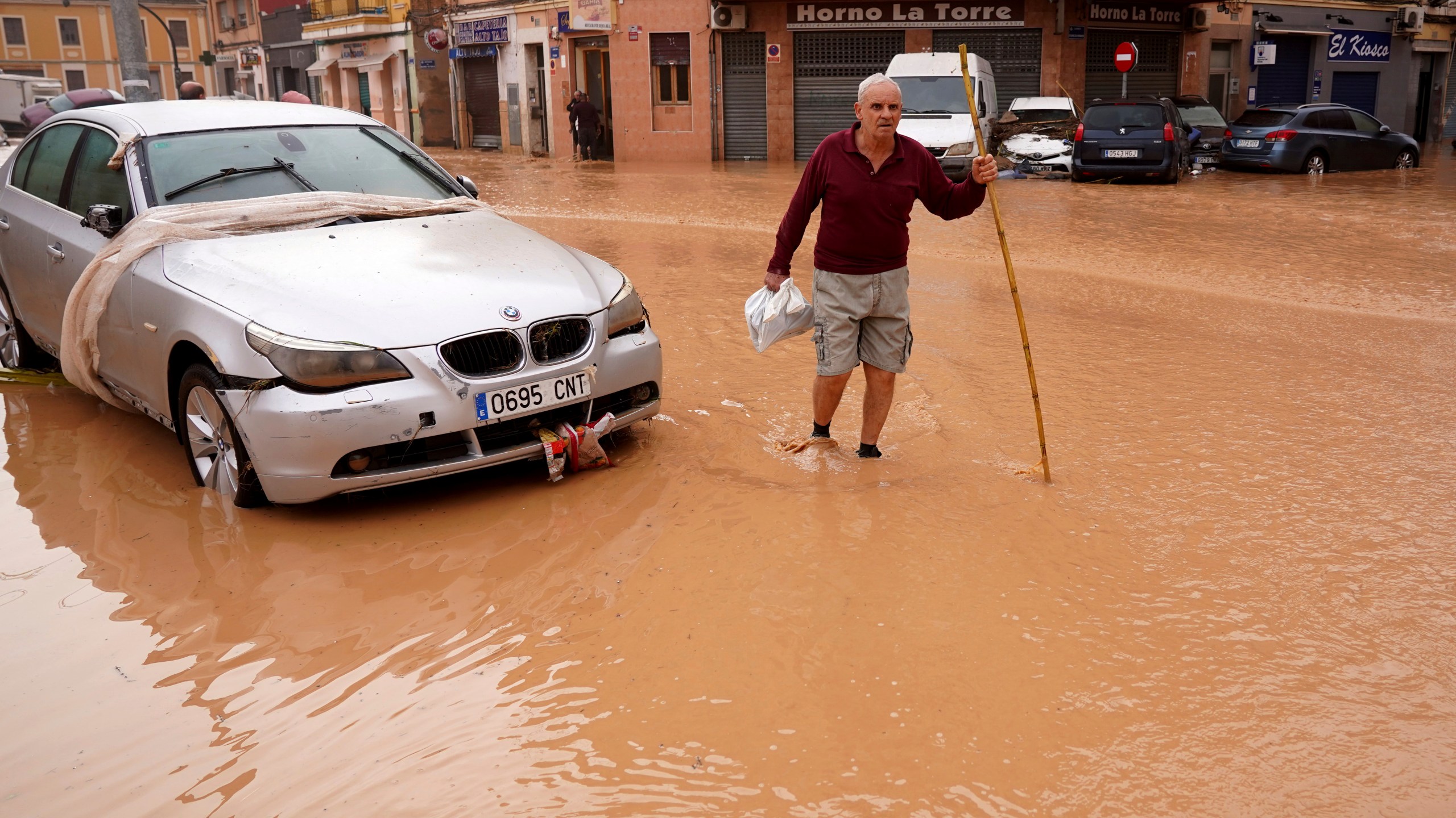 A man walks through flooded streets in Valencia, Spain, Wednesday, Oct. 30, 2024. (AP Photo/Alberto Saiz)