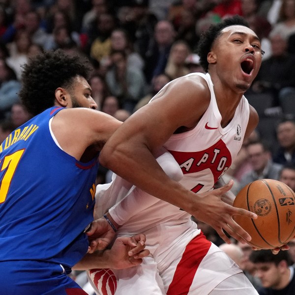 Toronto Raptors forward Scottie Barnes, right, reacts as he drives into Denver Nuggets guard Jamal Murray, left, during first-half NBA basketball game action in Toronto, Monday, Oct. 28, 2024. (Nathan Denette/The Canadian Press via AP)