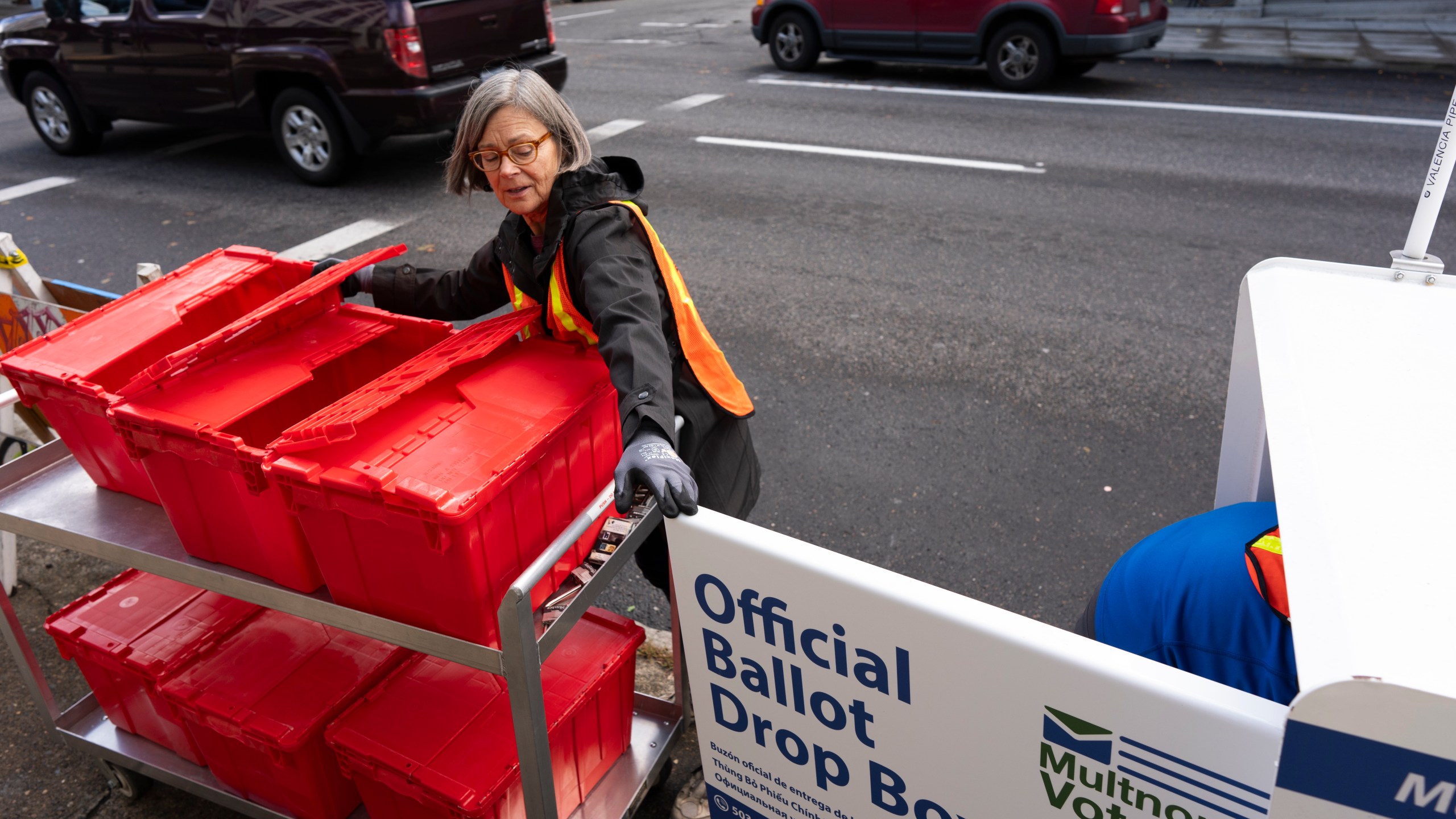 Election workers collect ballots from a newly placed ballot drop box outside the Multnomah County Elections Division office on Monday, Oct. 28, 2024, in Portland, Ore. (AP Photo/Jenny Kane)