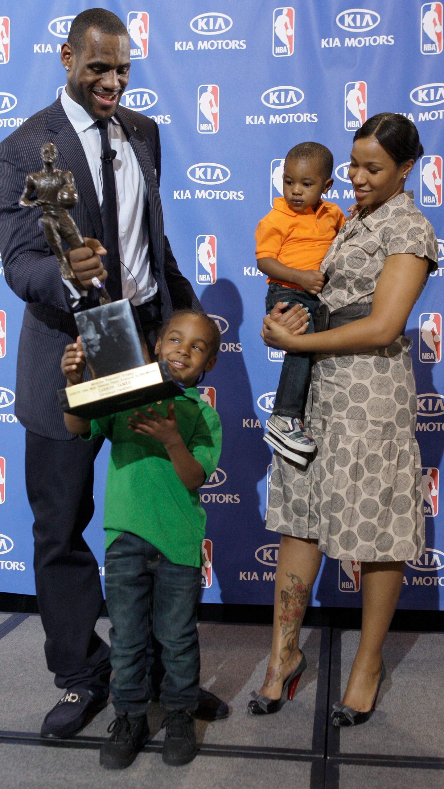 FILE - After accepting the NBA Most Valuable Player award during a ceremony at James' alma mater, Akron St. Vincent-St. Mary High School, in Akron, Ohio, Monday, May 4, 2009, Cleveland Cavaliers LeBron James hands the trophy to his son Lebron Jr., 4, as James girlfriend Savannah Brinson and their youngest son Bryce look on. (AP Photo/Amy Sancetta, File)