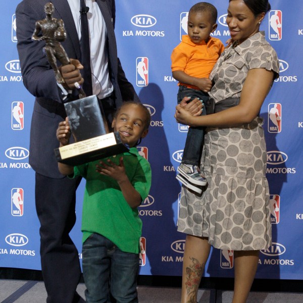 FILE - After accepting the NBA Most Valuable Player award during a ceremony at James' alma mater, Akron St. Vincent-St. Mary High School, in Akron, Ohio, Monday, May 4, 2009, Cleveland Cavaliers LeBron James hands the trophy to his son Lebron Jr., 4, as James girlfriend Savannah Brinson and their youngest son Bryce look on. (AP Photo/Amy Sancetta, File)