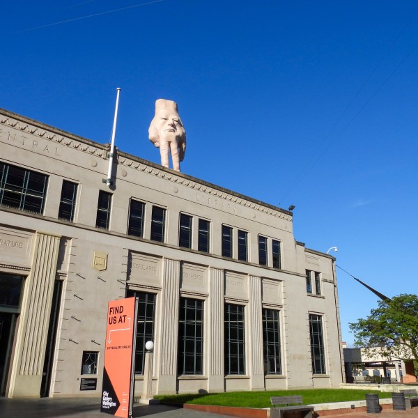 A 16-foot- ( almost 5 meters ) tall hand sculpture named Quasi stands perched on its fingertips atop the roof of an art gallery in Wellington, New Zealand, Wednesday, Oct. 30, 2024. (AP photo/Charlotte Graham-McLay)