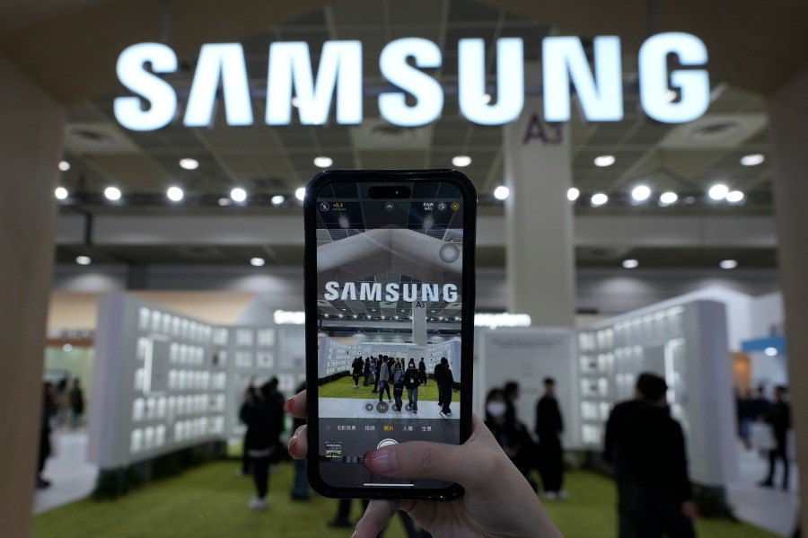 A visitor takes a picture of the logo of Samsung Electronics at its booth during The Semiconductor Exhibition 2024 at the COEX convention center in Seoul, South Korea, Wednesday, Oct. 23, 2024. (AP Photo/Ahn Young-joon)