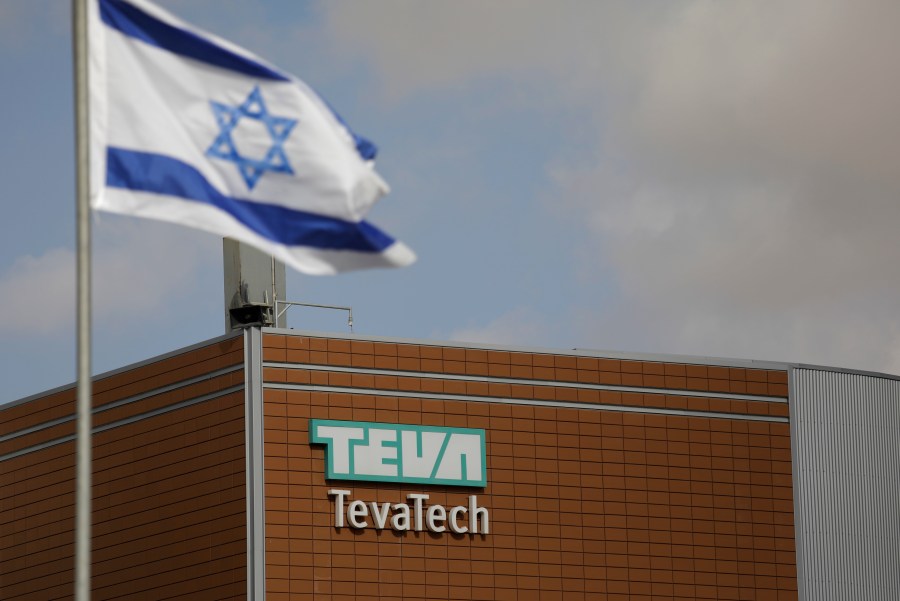 FILE - Israeli flag flies outside Teva Pharmaceutical facility building in Neot Hovav, Israel, on Dec. 14, 2017. (AP Photo/Tsafrir Abayov, File)