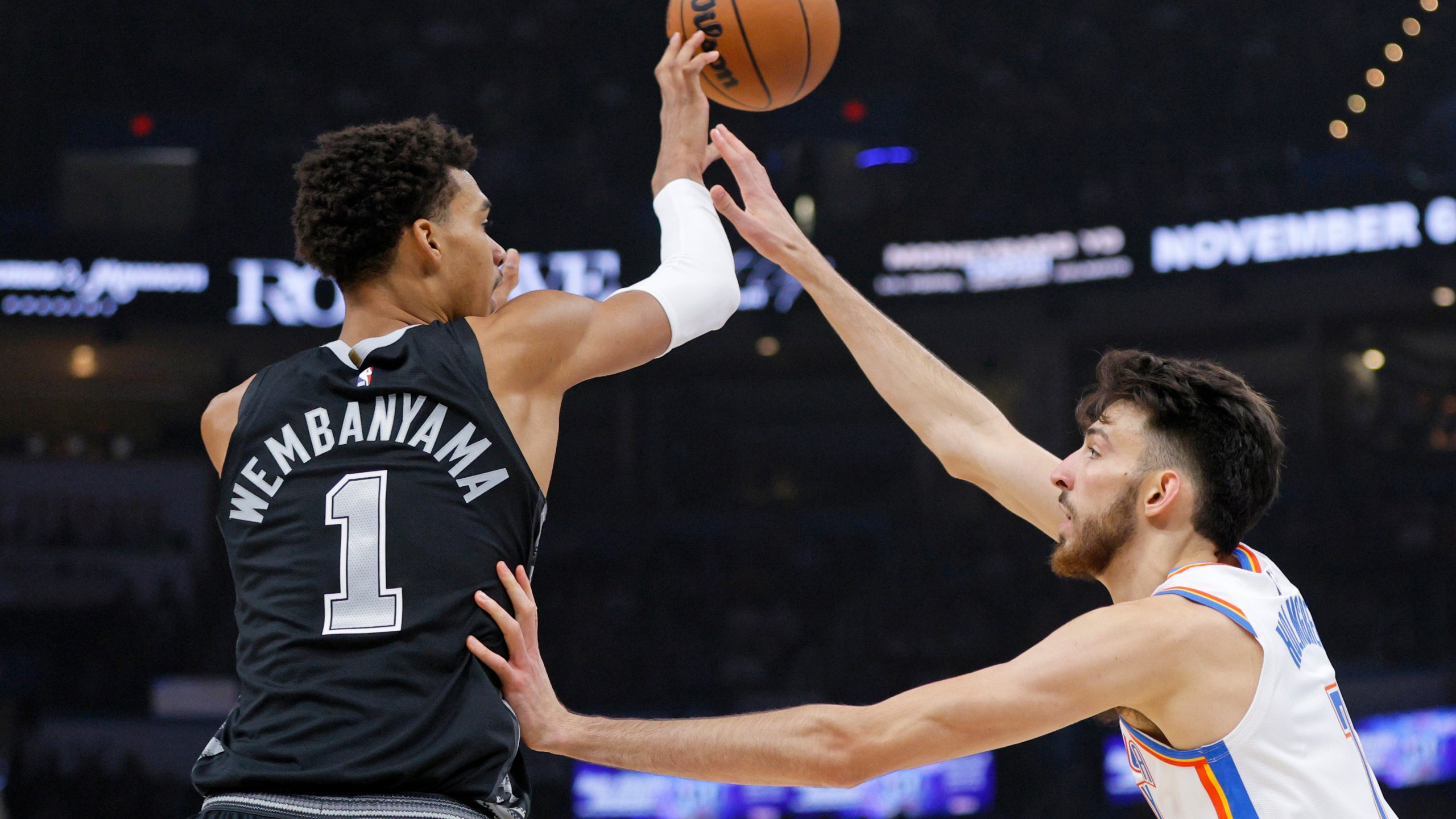 San Antonio Spurs center Victor Wembanyama (1) passes the ball over Oklahoma City Thunder forward Chet Holmgren, right, during the first half of an NBA basketball game Wednesday, Oct. 30, 2024, in Oklahoma City. (AP Photo/Nate Billings)