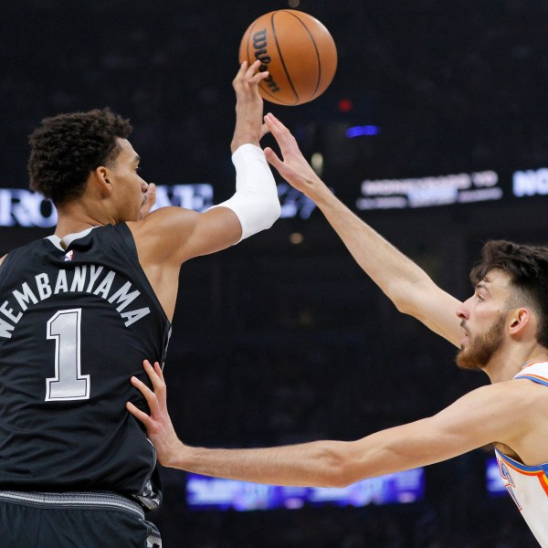 San Antonio Spurs center Victor Wembanyama (1) passes the ball over Oklahoma City Thunder forward Chet Holmgren, right, during the first half of an NBA basketball game Wednesday, Oct. 30, 2024, in Oklahoma City. (AP Photo/Nate Billings)