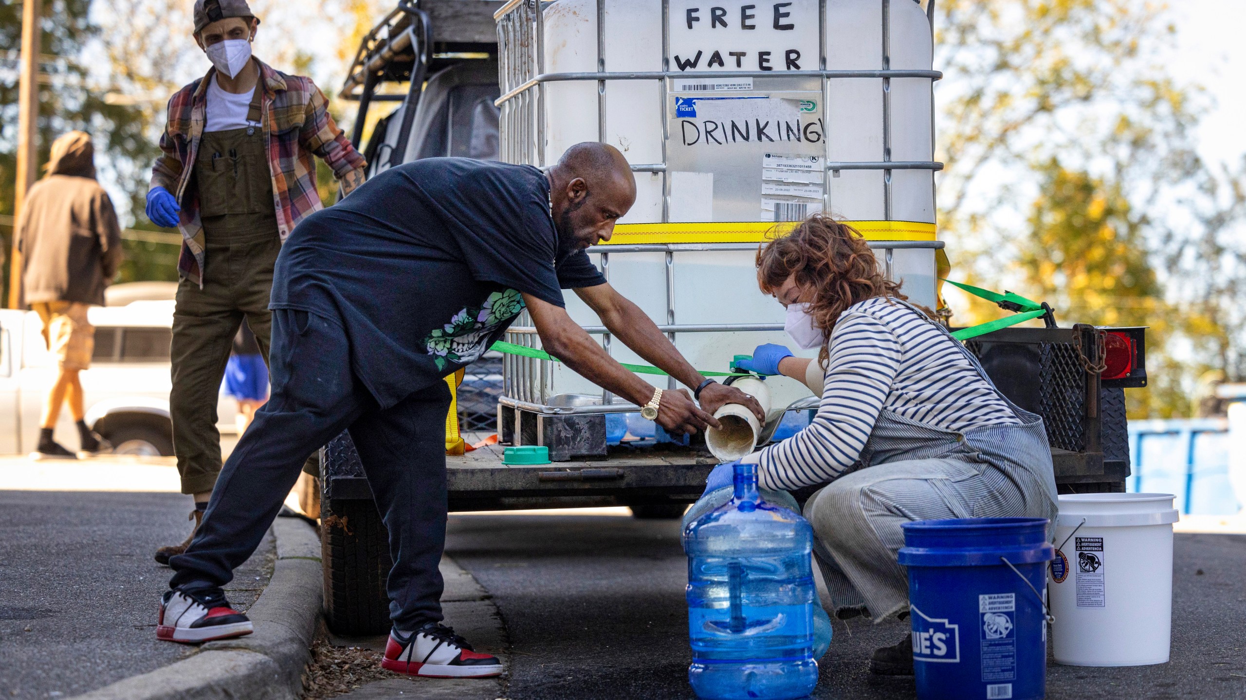 FILE - Volunteers with the grassroots group BeLoved Asheville fill bottles of drinking water for residents in low-income independent living facilities without running water, Oct. 8, 2024, in Asheville, N.C. (Travis Long/The News & Observer via AP, File)