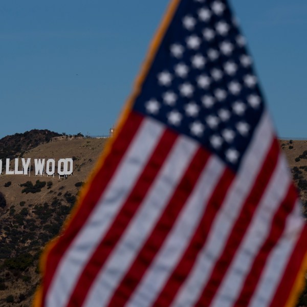 With the Hollywood sign in the background, an American flag stands during a naturalization ceremony at Griffith Observatory in Los Angeles, Monday, Oct. 21, 2024. (AP Photo/Jae C. Hong)