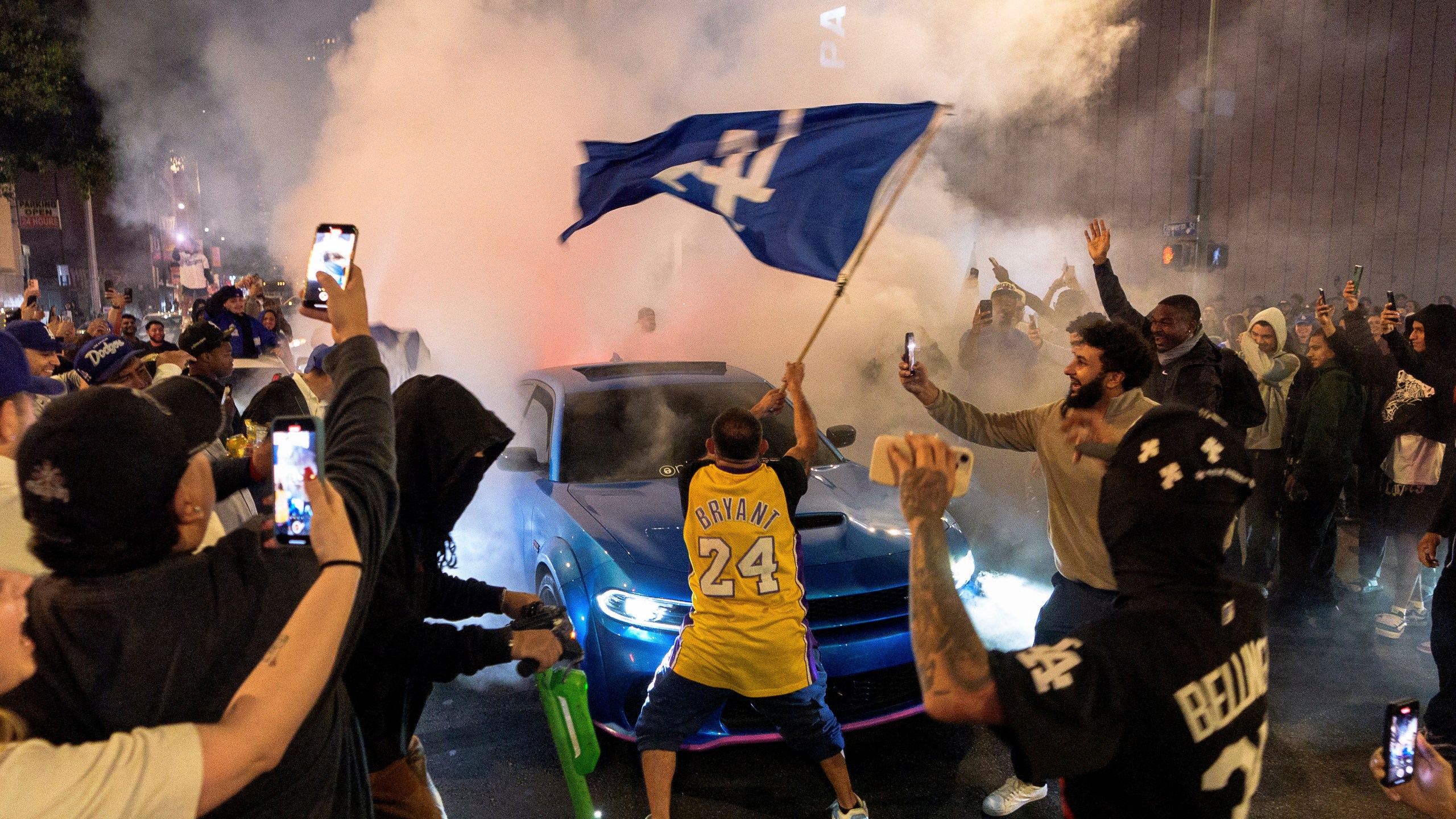 Fans celebrate on the streets after the Los Angeles Dodgers won against the New York Yankees in the baseball World Series Wednesday, Oct. 30, 2024, in downtown Los Angeles. (AP Photo/Damian Dovarganes)