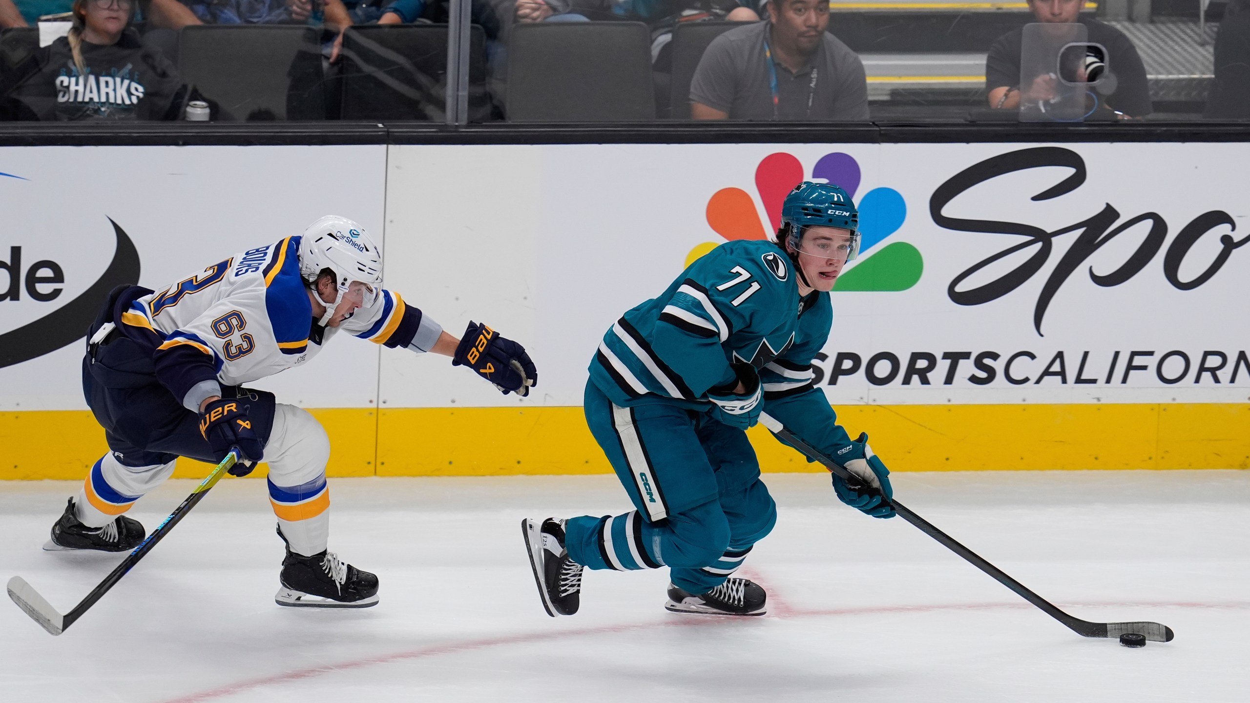 St. Louis Blues left wing Jake Neighbours, left, chases after San Jose Sharks center Macklin Celebrini, right, during the first period of an NHL hockey game Thursday, Oct. 10, 2024, in San Jose, Calif. (AP Photo/Godofredo A. Vásquez)