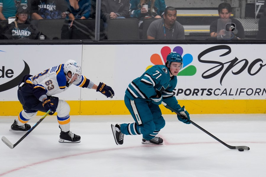 St. Louis Blues left wing Jake Neighbours, left, chases after San Jose Sharks center Macklin Celebrini, right, during the first period of an NHL hockey game Thursday, Oct. 10, 2024, in San Jose, Calif. (AP Photo/Godofredo A. Vásquez)