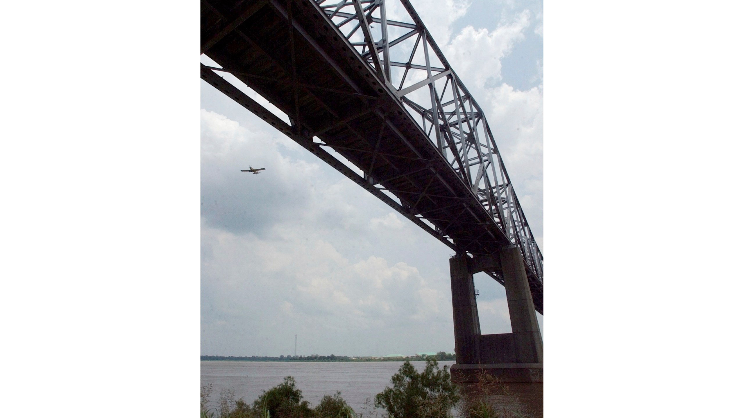 FILE - An agricultural airplane flies near the Highway 49 bridge over the Mississippi River near Helena, Ark., on June 10, 2004. (AP Photo/Danny Johnston, File)