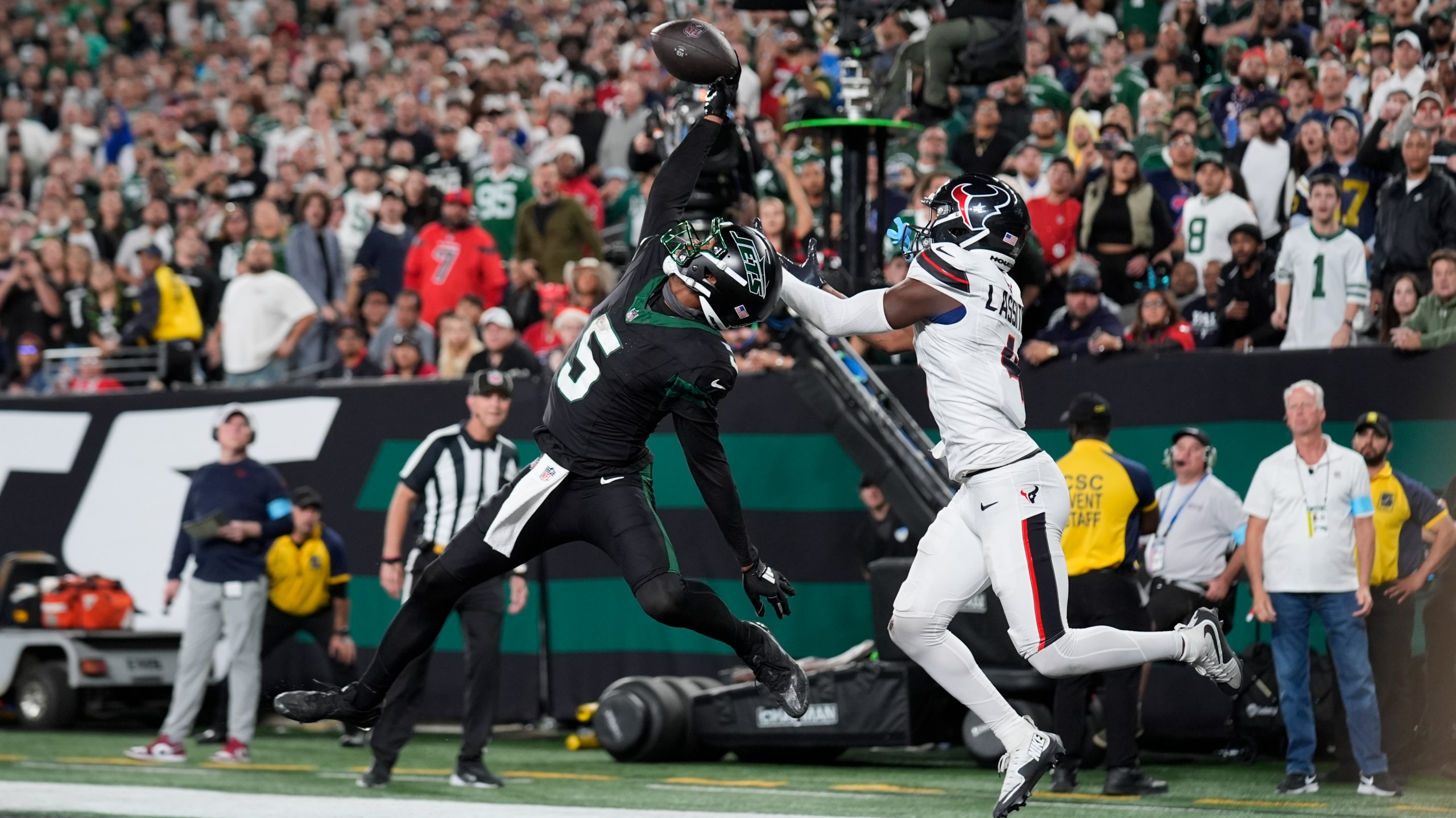 New York Jets wide receiver Garrett Wilson (5) catches a pass for a touchdown as Houston Texans cornerback Kamari Lassiter (4) defends during the second half of an NFL football game Thursday, Oct. 31, 2024, in East Rutherford, N.J. (AP Photo/Seth Wenig)