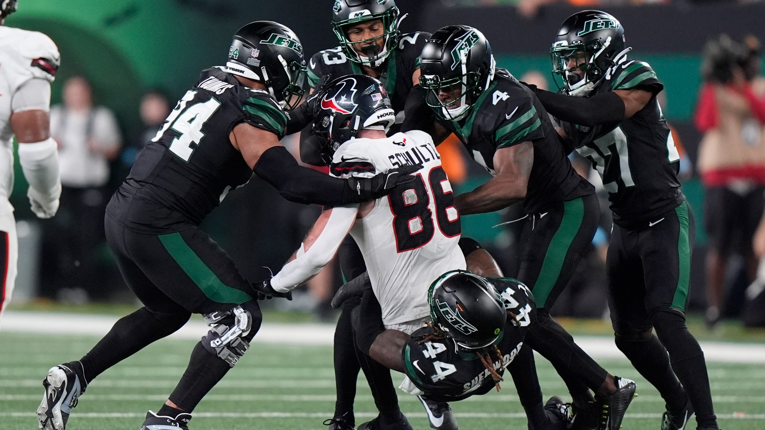 New York Jets linebacker Jamien Sherwood (44) and teammates tackle Houston Texans tight end Dalton Schultz (86) during the second half of an NFL football game Thursday, Oct. 31, 2024, in East Rutherford, N.J. (AP Photo/Frank Franklin II)