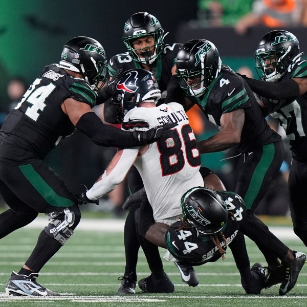 New York Jets linebacker Jamien Sherwood (44) and teammates tackle Houston Texans tight end Dalton Schultz (86) during the second half of an NFL football game Thursday, Oct. 31, 2024, in East Rutherford, N.J. (AP Photo/Frank Franklin II)