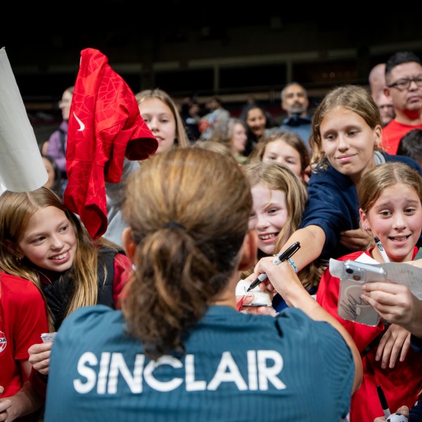 Portland Thorns FC's Christine Sinclair signs autographs for fans after a CONCACAF W Champions Cup match against the Vancouver Whitecaps in Vancouver, British Columbia, Tuesday, Oct. 15, 2024. (Ethan Cairns/The Canadian Press via AP)