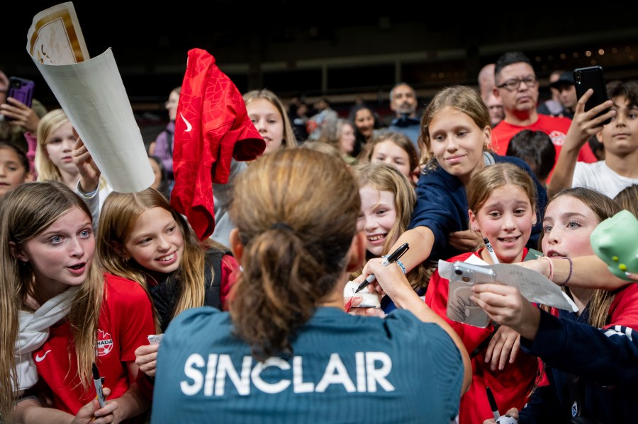 Portland Thorns FC's Christine Sinclair signs autographs for fans after a CONCACAF W Champions Cup match against the Vancouver Whitecaps in Vancouver, British Columbia, Tuesday, Oct. 15, 2024. (Ethan Cairns/The Canadian Press via AP)