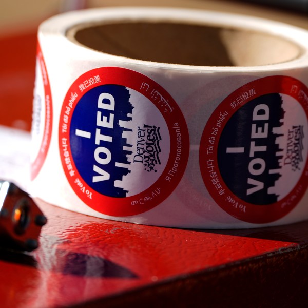 Stickers for voters sit in a roll on a ballot box at a voting drop-off location Friday, Oct. 25, 2024, in Washington Park in Denver. (AP Photo/David Zalubowski)