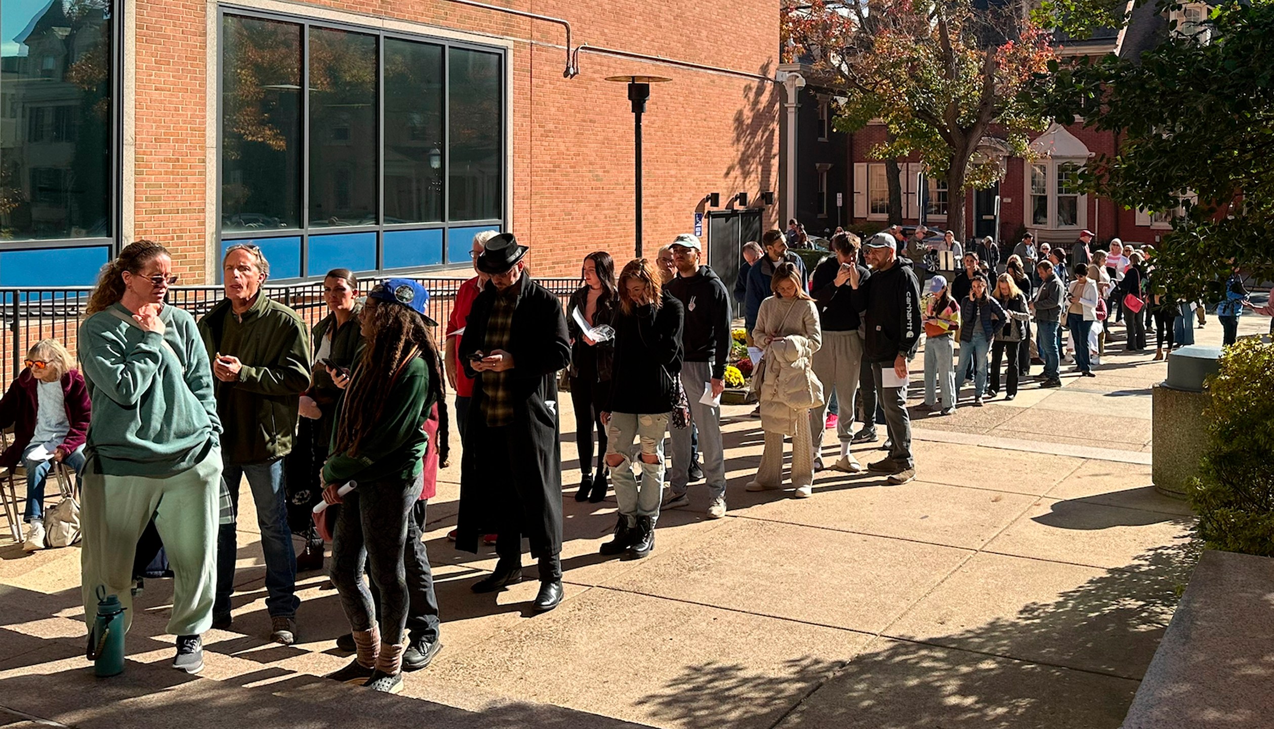 People wait in line outside the Bucks County government building to apply for an on-demand mail ballot on the last day to request one in Doylestown, Pa., Tuesday, Oct. 29, 2024. (AP Photo/Mike Catalini)