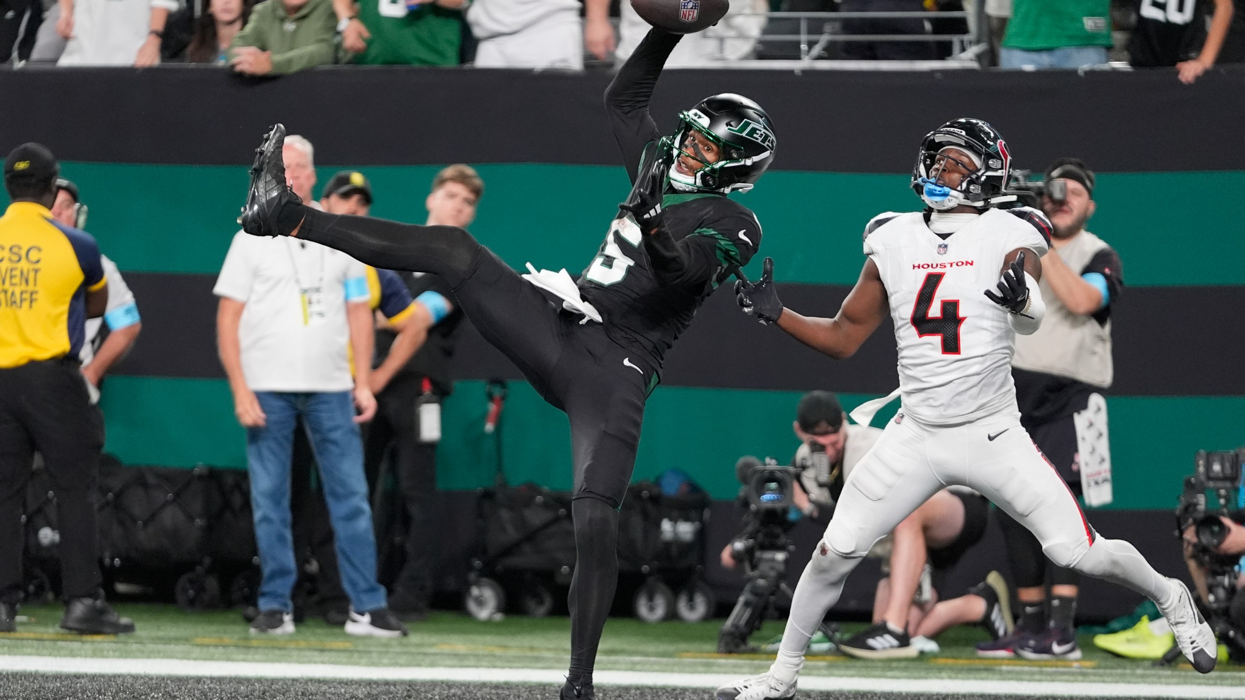 CORRECTS BYLINE - New York Jets wide receiver Garrett Wilson (5) catches a pass for a touchdown as Houston Texans cornerback Kamari Lassiter (4) defends during the second half of an NFL football game Thursday, Oct. 31, 2024, in East Rutherford, N.J. (AP Photo/Frank Franklin II)