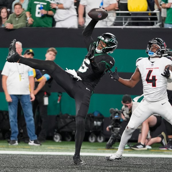 CORRECTS BYLINE - New York Jets wide receiver Garrett Wilson (5) catches a pass for a touchdown as Houston Texans cornerback Kamari Lassiter (4) defends during the second half of an NFL football game Thursday, Oct. 31, 2024, in East Rutherford, N.J. (AP Photo/Frank Franklin II)