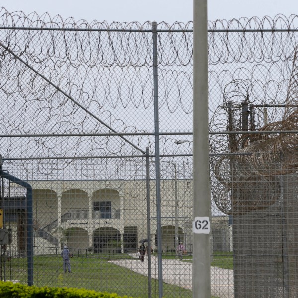 FILE - A prisoner works on the lawn at the Dade Correctional Institution, July 10, 2014, in Florida City, Fla. (AP Photo/Lynne Sladky, File)