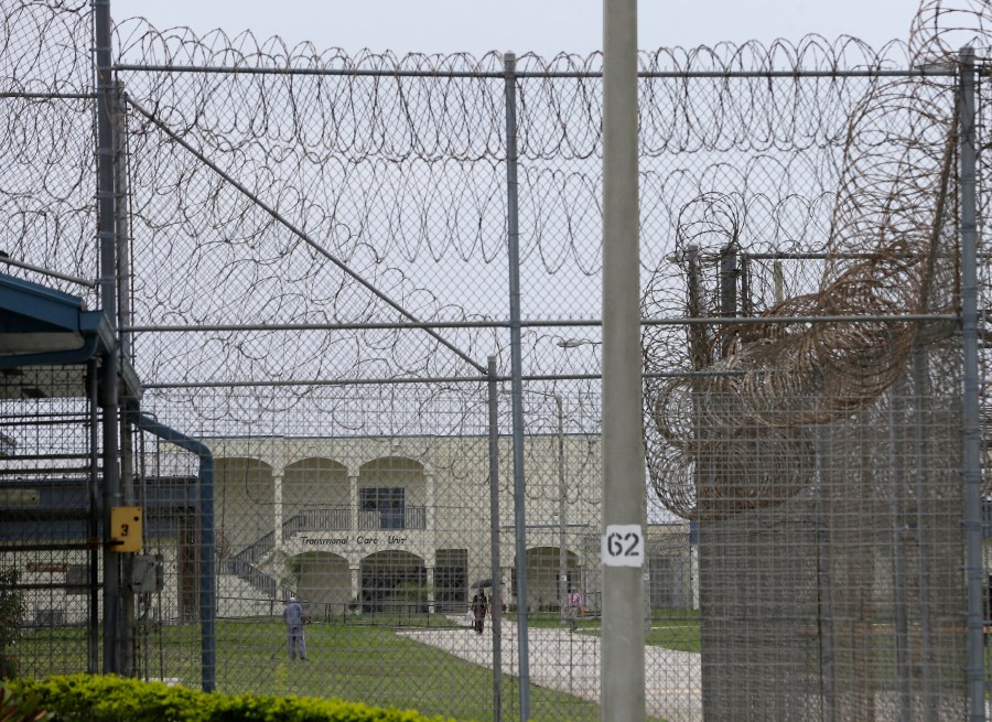 FILE - A prisoner works on the lawn at the Dade Correctional Institution, July 10, 2014, in Florida City, Fla. (AP Photo/Lynne Sladky, File)