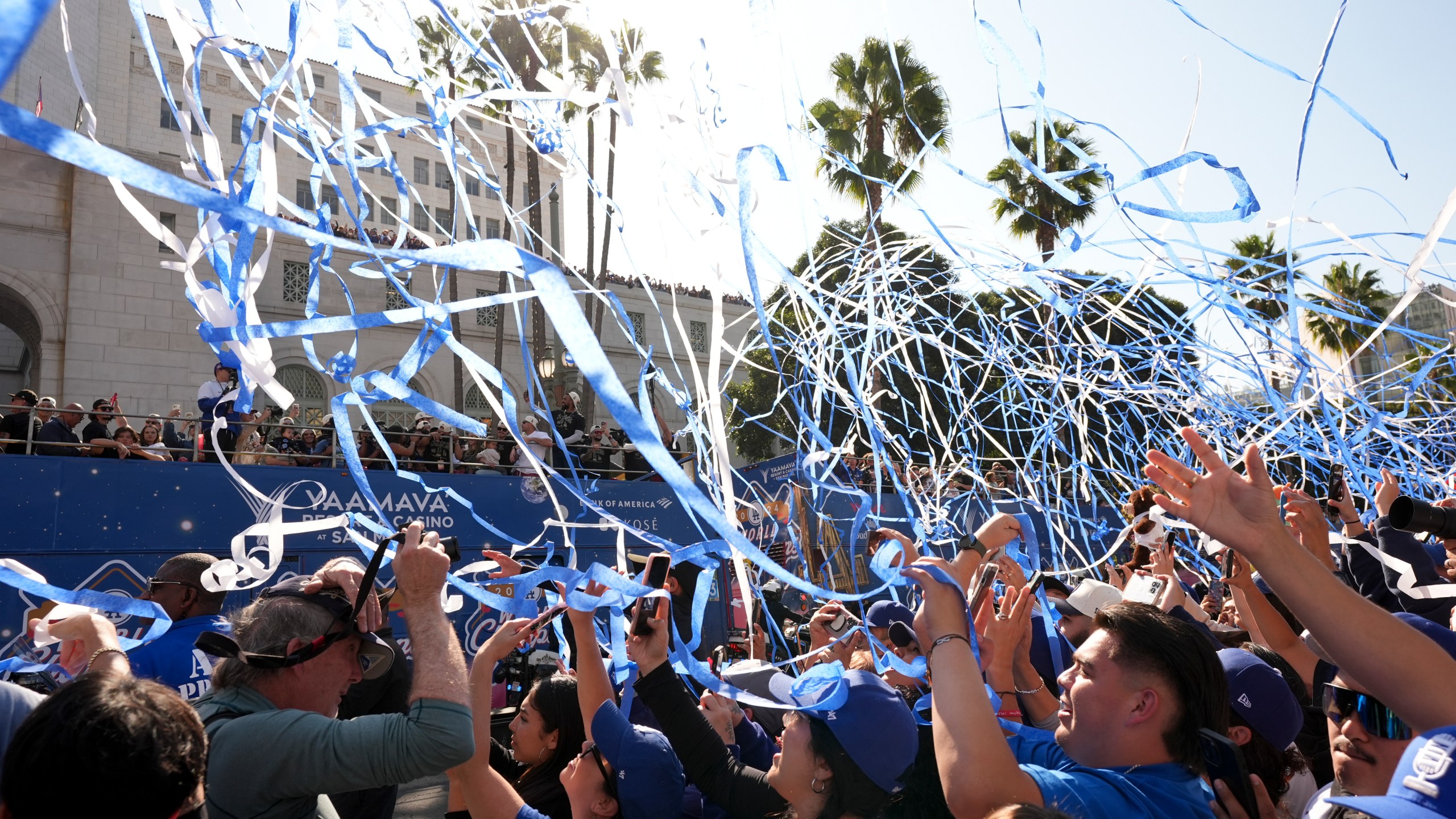 Fans cheer as buses carrying players are driven past during the Los Angeles Dodgers baseball World Series championship parade Friday, Nov. 1, 2024, in Los Angeles. (AP Photo/Jae C. Hong)