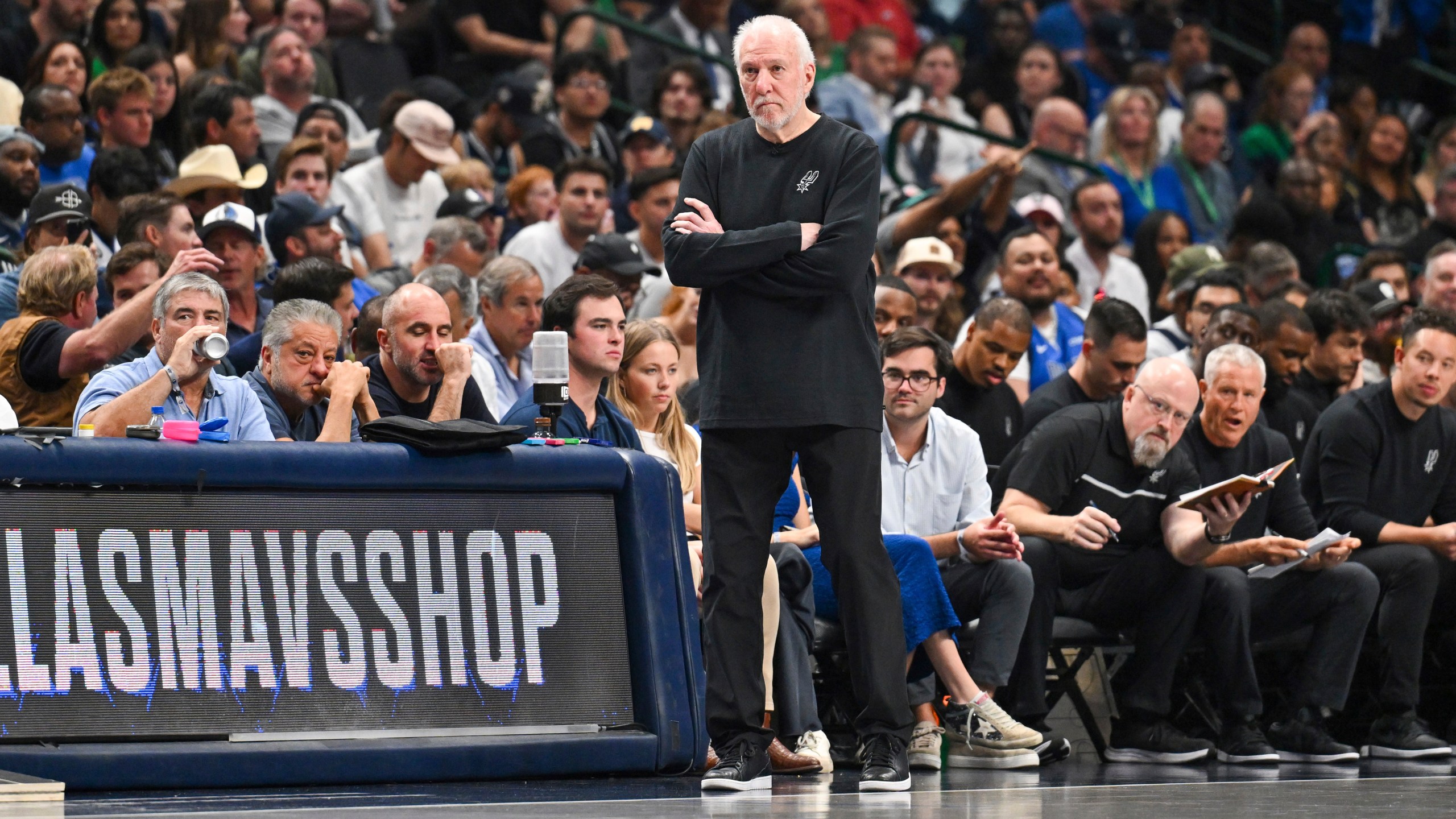 San Antonio Spurs' head coach Greg Popovich, center, watches free throws during the second half of an NBA basketball game against the Dallas Mavericks, Thursday, Oct. 24, 2024, in Dallas, Texas. (AP Photo/Albert Pena)