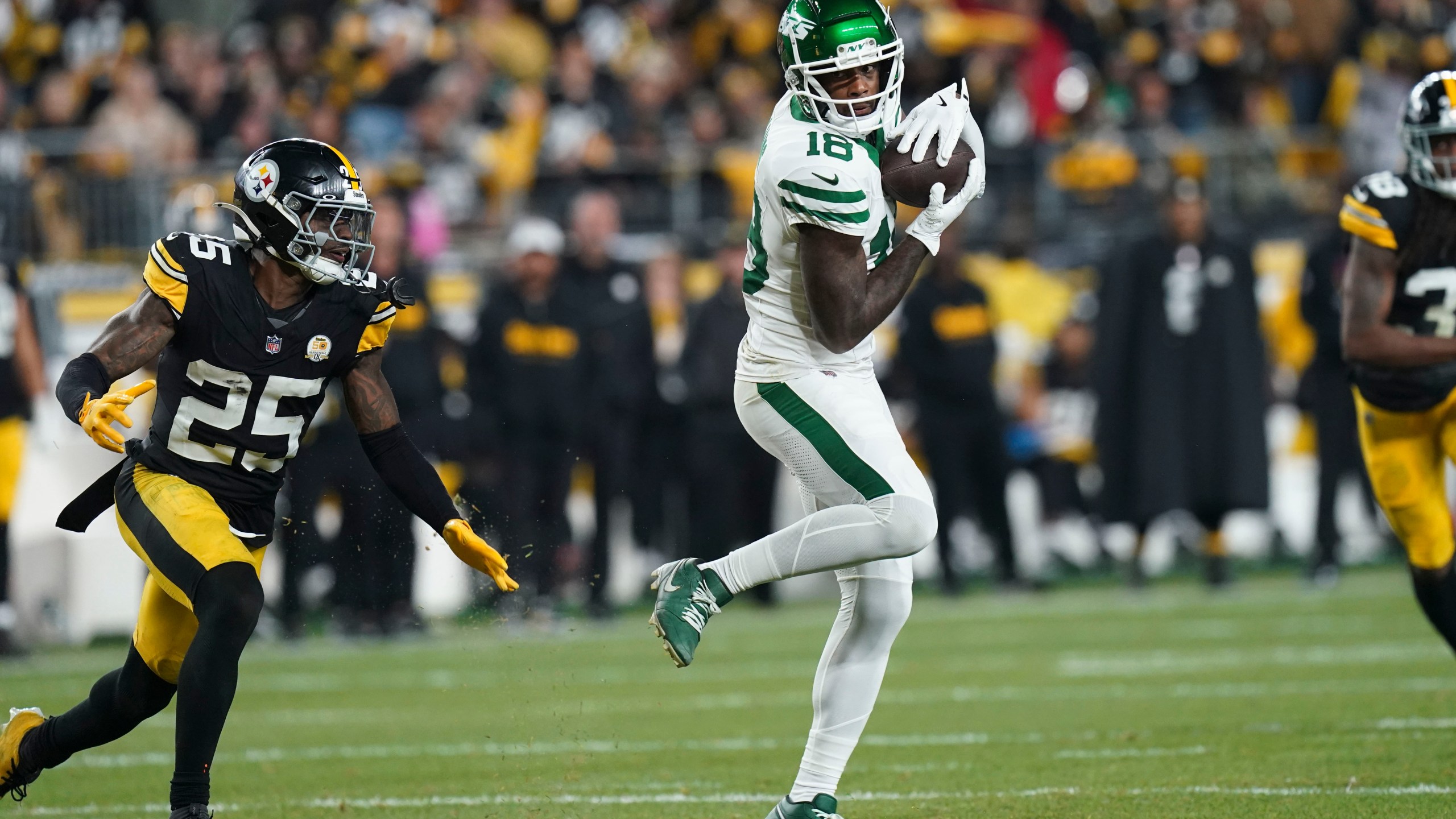 New York Jets wide receiver Mike Williams (18) pulls in a pass against Pittsburgh Steelers safety DeShon Elliott (25) in the second half of an NFL football game in Pittsburgh, Sunday, Oct. 20, 2024. (AP Photo/Matt Freed)