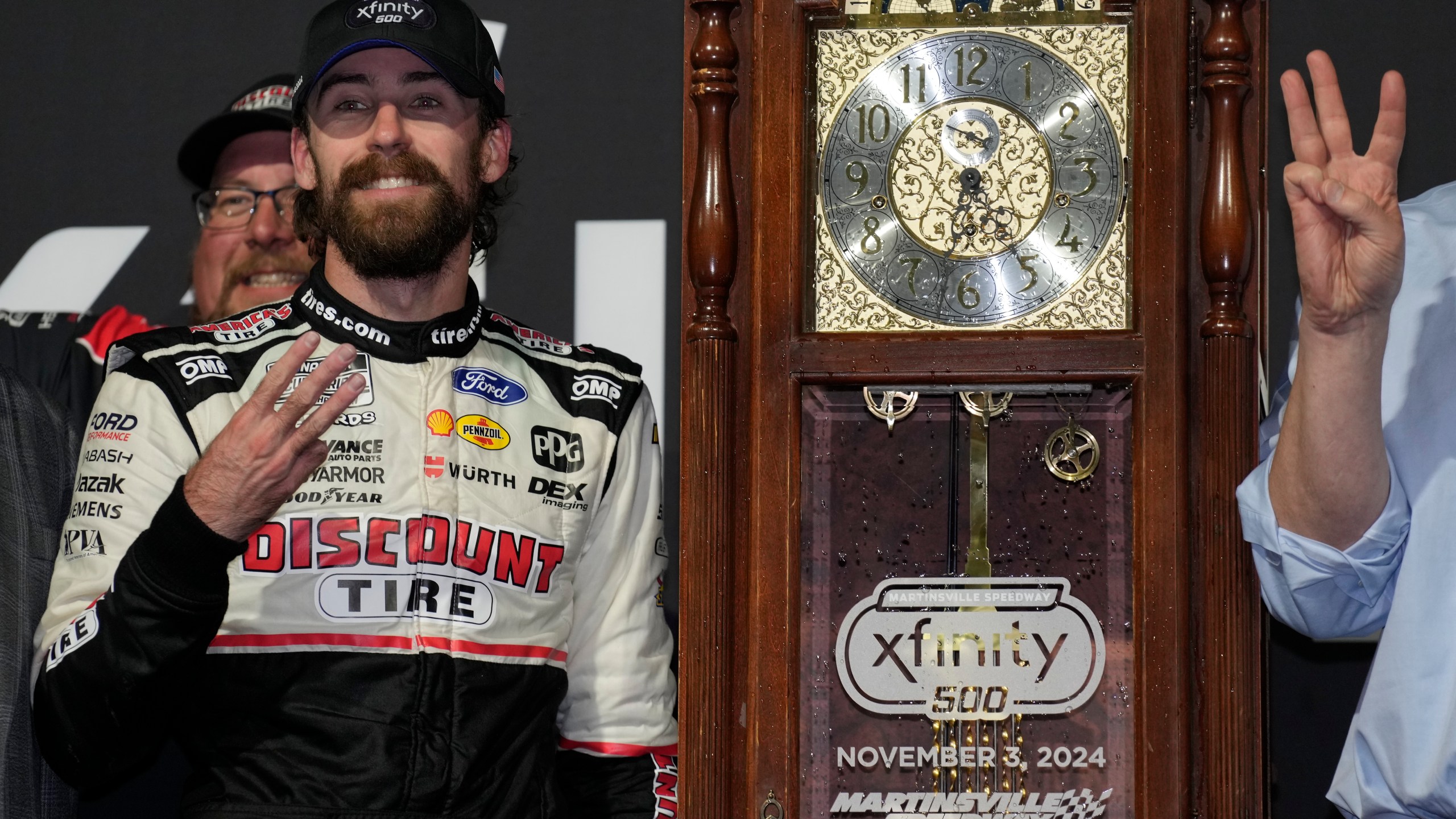 Ryan Blaney, front left, poses with the trophy in Victory Lane after winning a NASCAR Cup Series auto race at Martinsville Speedway in Martinsville, Va., Sunday, Nov. 3, 2024. (AP Photo/Chuck Burton)