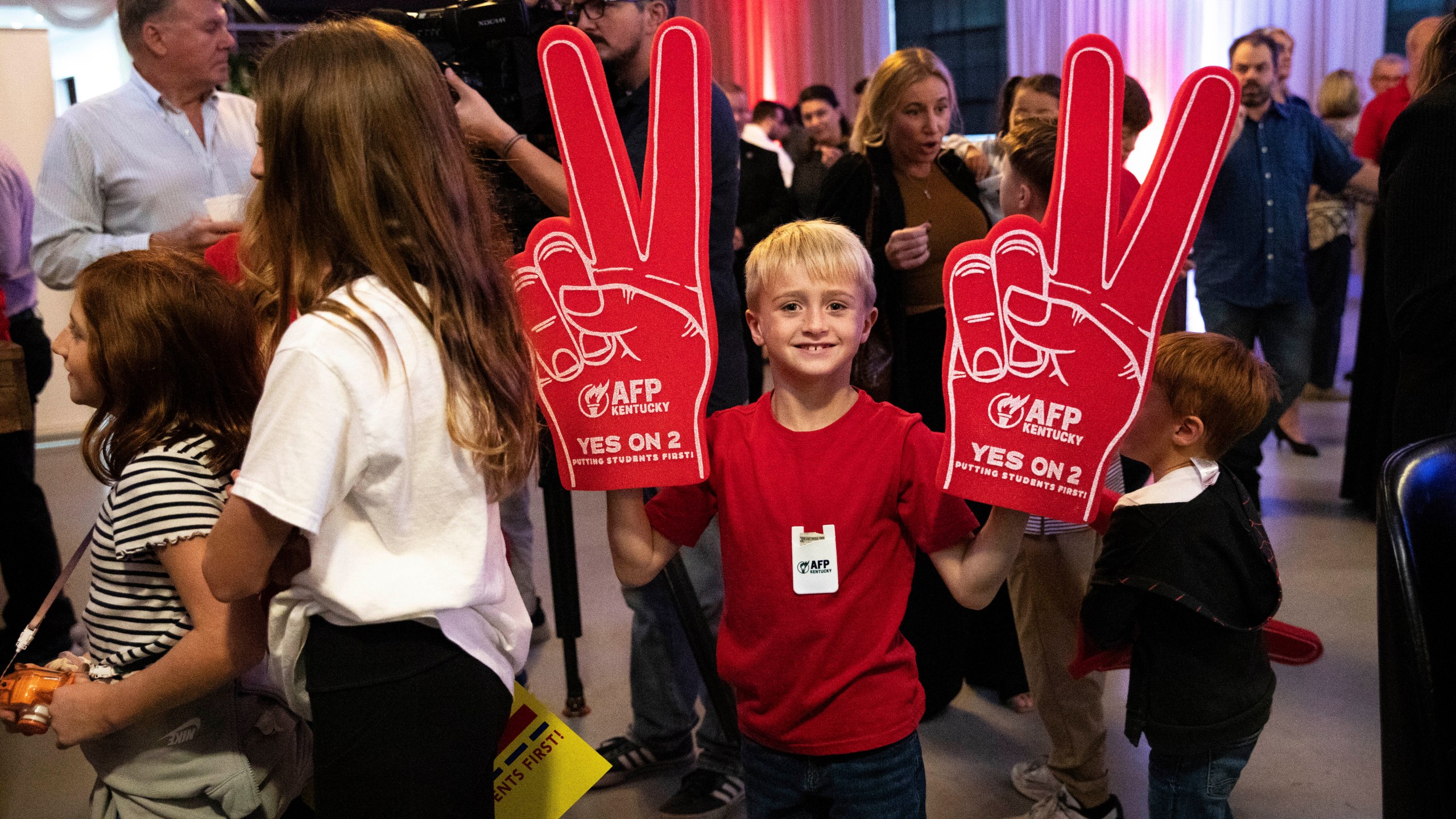 Samuel Towe, 8, holds up two pro-Amendment 2 foam fingers as he attends the Americans for Prosperity—Kentucky's rally featuring U.S. Sen. Rand Paul, and others in support of Kentucky's Amendment 2 with his family at La Gala in downtown Bowling Green, Ky., Monday, Oct. 28, 2024. (Grace Ramey McDowell/Daily News via AP)