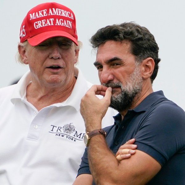 FILE - Former President Donald Trump, left, talks with Yasir Al-Rumayyan, governor of Saudi Arabia's Public Investment Fund, on the 16th hole during the first round of the Bedminster Invitational LIV Golf tournament in Bedminster, NJ., July 29, 2022. (AP Photo/Seth Wenig, File)