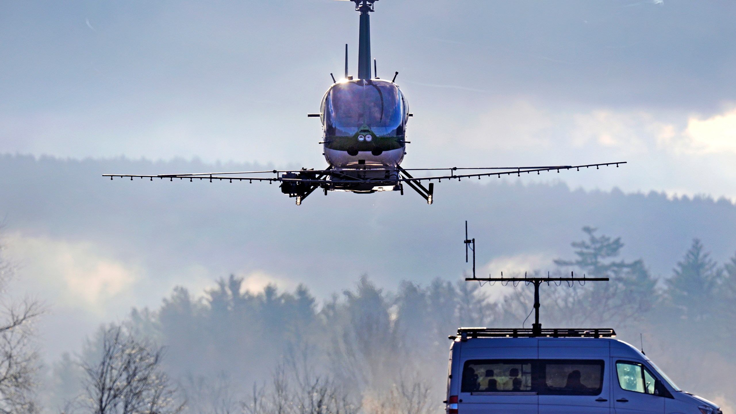 A Rotor Technologies unmanned semi-autonomous helicopter flies away from a van containing a ground control pilot/operator during a test flight over Intervale Airport, Monday, Nov. 11, 2024, in Henniker, N.H. (AP Photo/Charles Krupa)