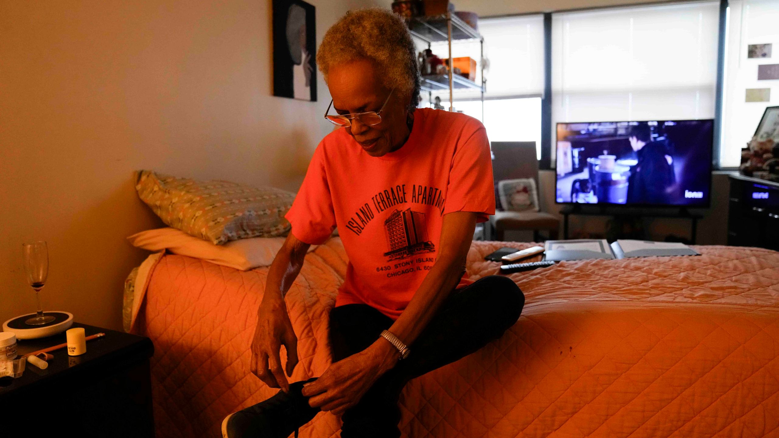 Bernadine Gibson, 82, puts on shoes as she prepares to see renovations being done to the building her family has lived in for 27 years, Monday, Nov. 18, 2024, in Chicago. (AP Photo/Erin Hooley)