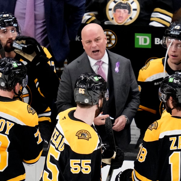 Boston Bruins head coach Jim Montgomery talks with his players during a time out during the third period of an NHL hockey game against the Philadelphia Flyers, Tuesday, Oct. 29, 2024, in Boston. (AP Photo/Charles Krupa)