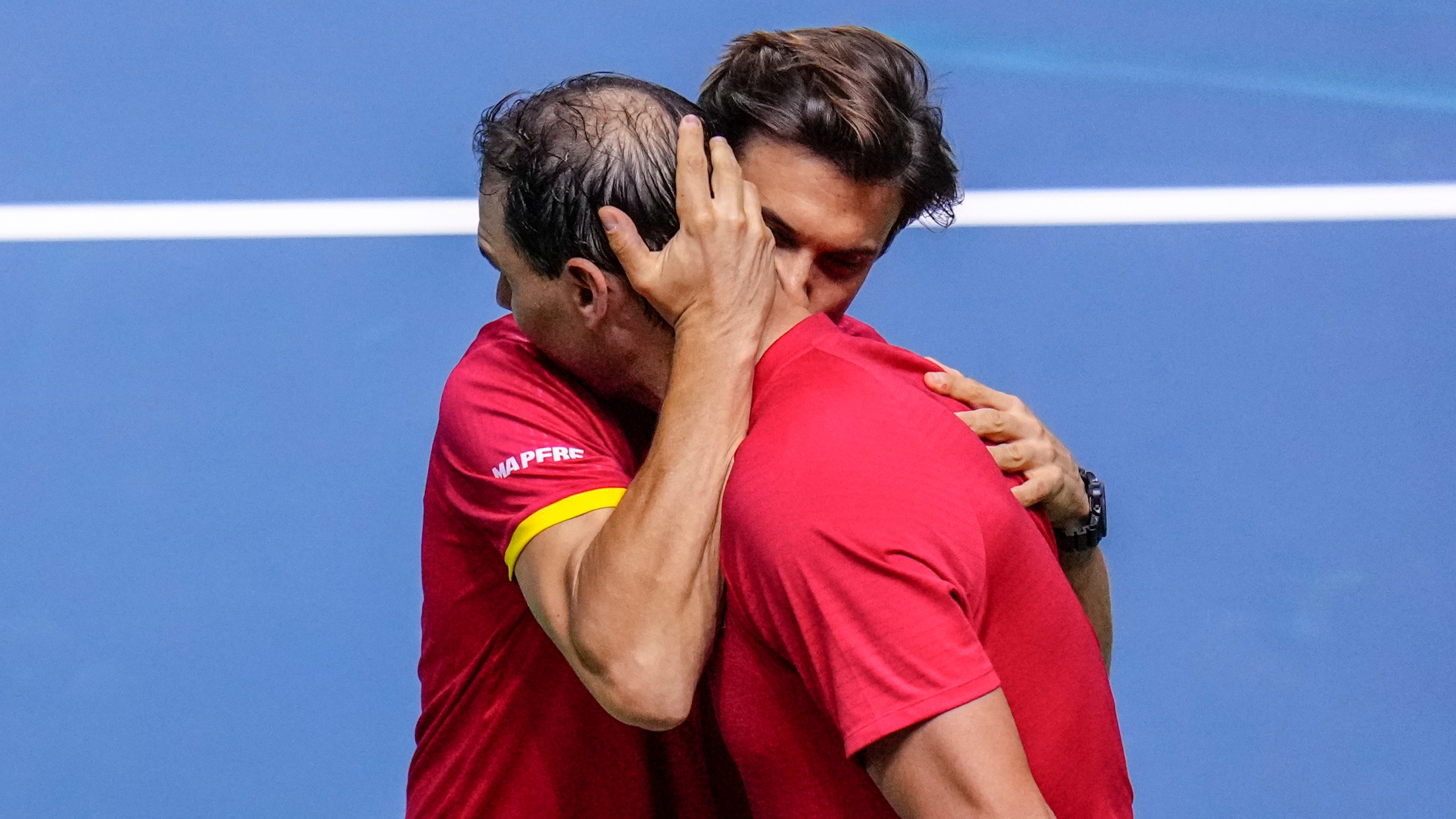 Spain's tennis player Rafael Nadal embraces David Ferrer, captain of Team Spain, after losing against Netherlands' Botic Van De Zandschulp during a Davis Cup quarterfinal match at Martin Carpena Sports Hall in Malaga, southern Spain, on Tuesday, Nov. 19, 2024. (AP Photo/Manu Fernandez)