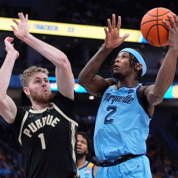 Marquette's Chase Ross shoots past Purdue's Caleb Furst during the first half of an NCAA college basketball game Tuesday, Nov. 19, 2024, in Milwaukee. (AP Photo/Morry Gash)