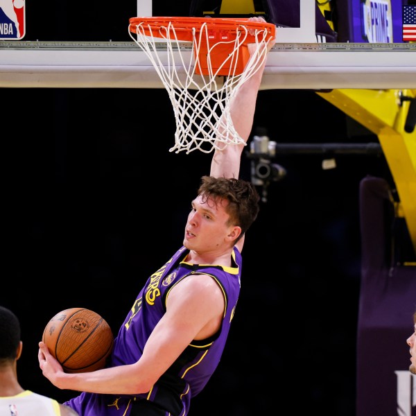 Los Angeles Lakers guard Dalton Knecht dunks during the first half of an Emirates NBA Cup basketball game agaianst the Utah Jazz, Tuesday, Nov. 19, 2024, in Los Angeles. (AP Photo/Etienne Laurent)