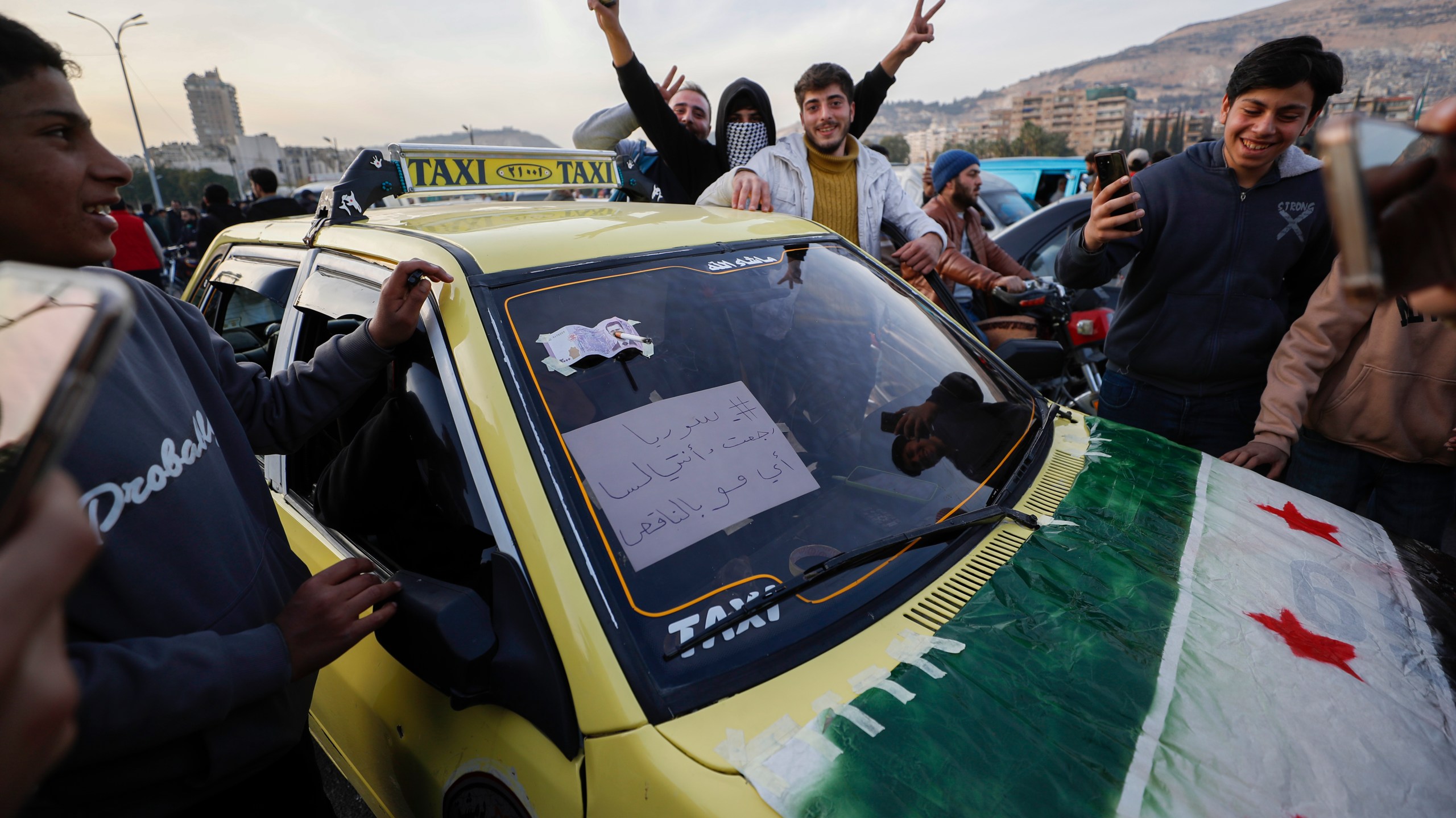 Syrian citizens celebrate during the third day of the take over of the city by the insurgents in Damascus, Syria, Tuesday, Dec. 10, 2024. (AP Photo/Omar Sanadiki)