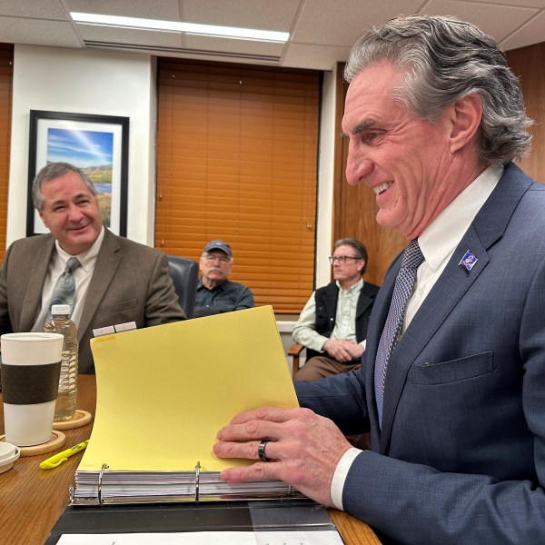 North Dakota Republican Gov. Doug Burgum, right, and Republican state Agriculture Commissioner Doug Goehring, left, prepare before a meeting of the state Industrial Commission on Thursday, Dec. 12, 2024, at the state Capitol in Bismarck, N.D. (AP Photo/Jack Dura)