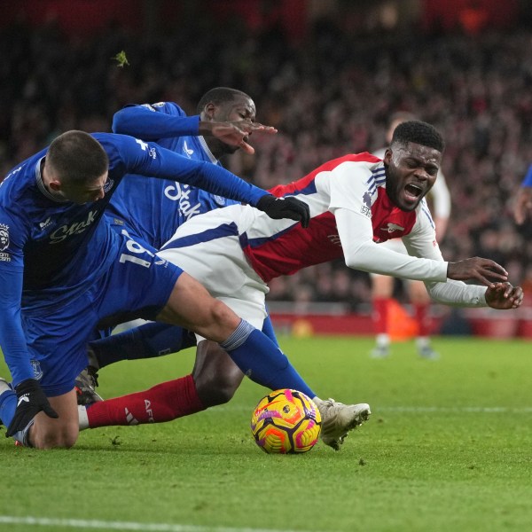 Arsenal's Thomas Partey, centre, challenges for the ball with Everton's Vitaliy Mykolenko during the English Premier League soccer match between Arsenal and Everton at Emirates Stadium in London, Saturday, Dec. 14, 2024. (AP Photo/Kin Cheung)