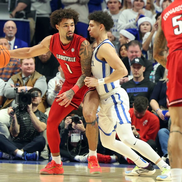 Louisville's J'Vonne Hadley (1) looks for an opening against Kentucky's Koby Brea, center right, during the first half of an NCAA college basketball game in Lexington, Ky., Saturday, Dec. 14, 2024. (AP Photo/James Crisp)